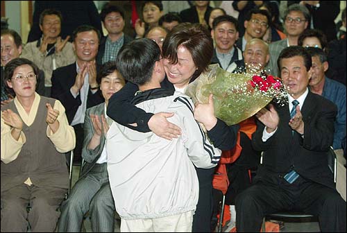 4월 15일 당사에서 개표방송을 지켜보던 심상정 당선자가 아들 이우준 군의 축하 꽃다발을 받고 기뻐하고 있다. 